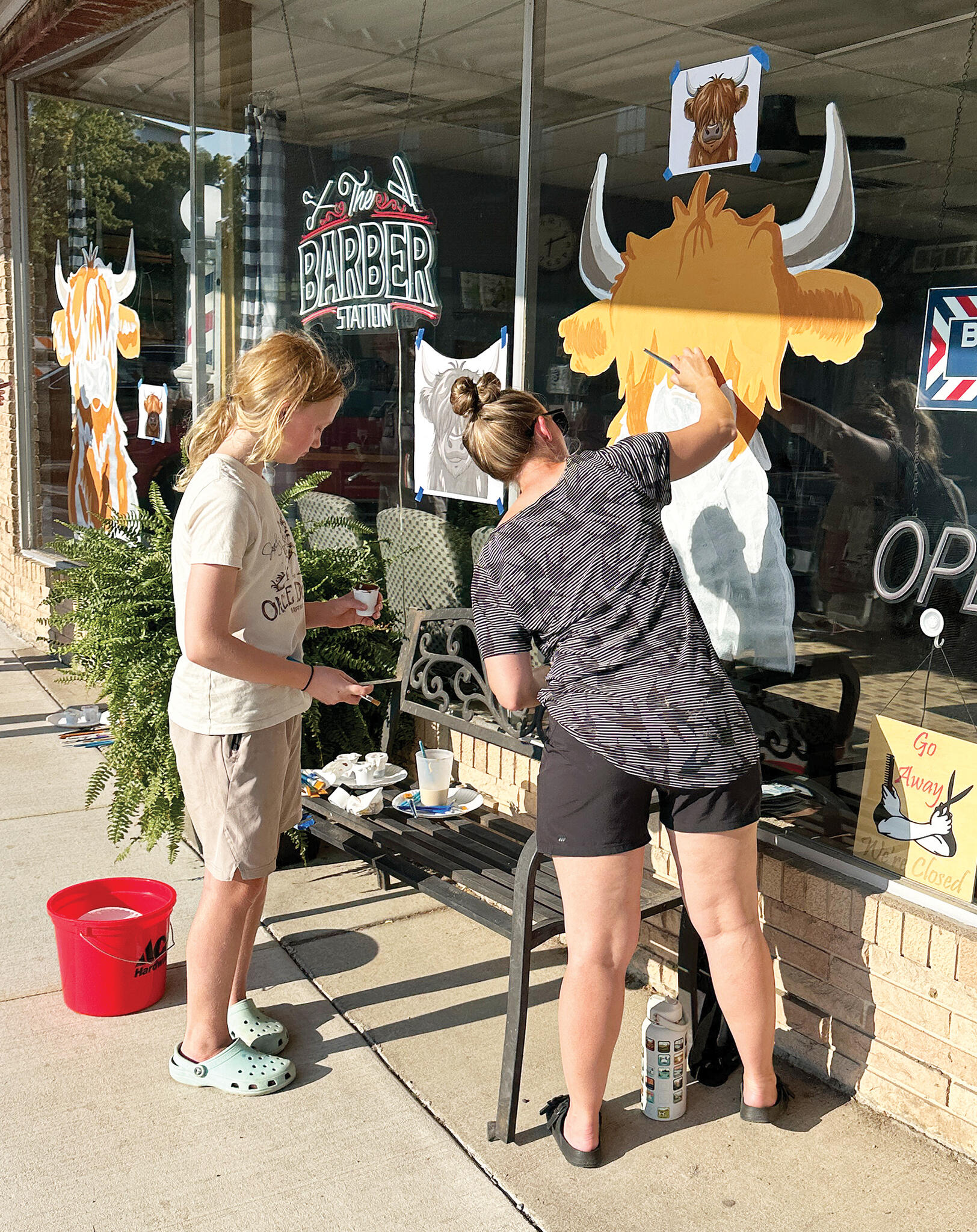 Stephanie (right) and Aurelia (left) Eichman add artistic detail to a shaggy-haired bison.