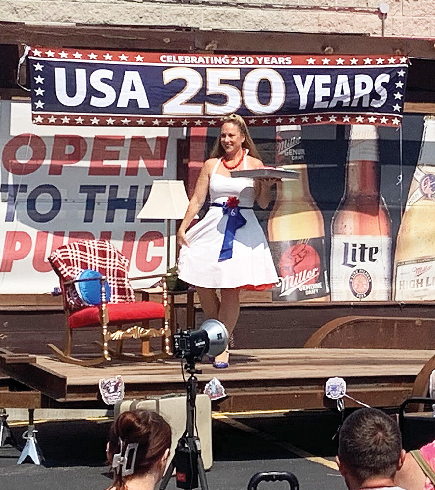 Pin-up contestant Betty Margaret carries a tray of cupcakes across the stage.