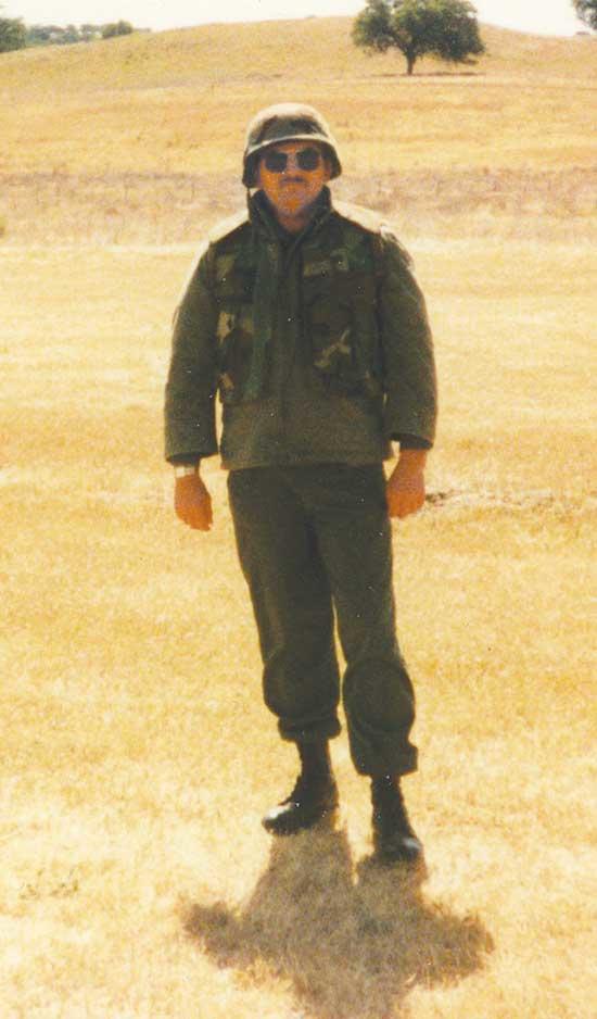 Edwards standing alone in full military gear during military training at United States Marine Base Camp Pendelton, California. He attended training as part of military field exercise with Marine units stationed there.