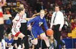 STMA’s Mackenzie Kramer (right) dribbles by a defender in a 67-58 state quarterfinal victory over Lakeville North. In the background is Head Coach Kent Hamre. (Photo by Rob LaPlante)